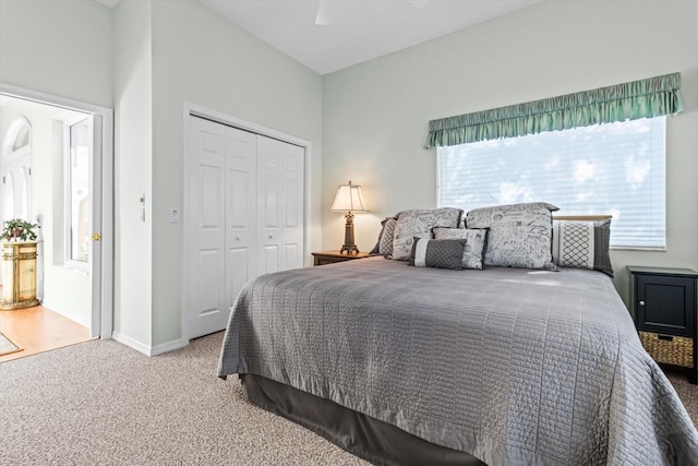 carpeted bedroom with multiple windows, a closet, and ceiling fan