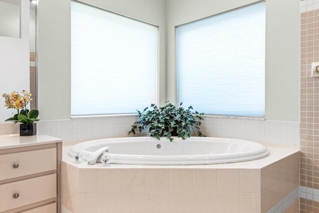 bathroom with vanity and a relaxing tiled tub