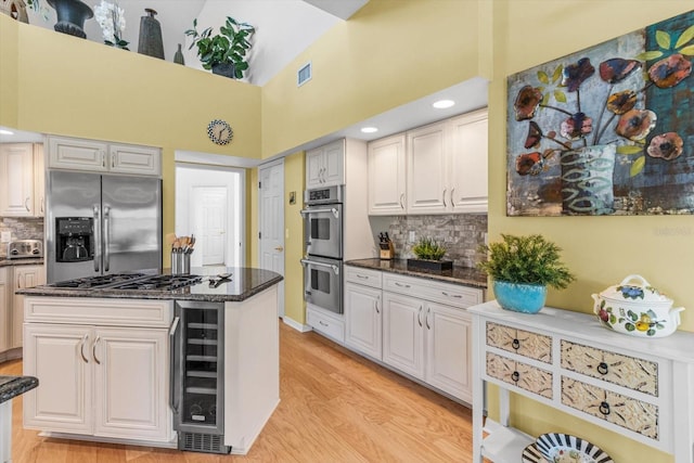 kitchen featuring backsplash, white cabinetry, stainless steel appliances, and wine cooler