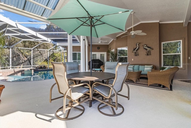 view of patio / terrace with an outdoor living space, glass enclosure, and ceiling fan