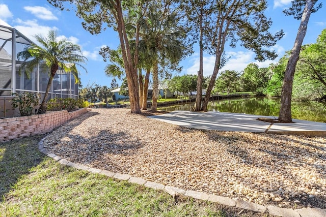 view of yard with a water view and glass enclosure