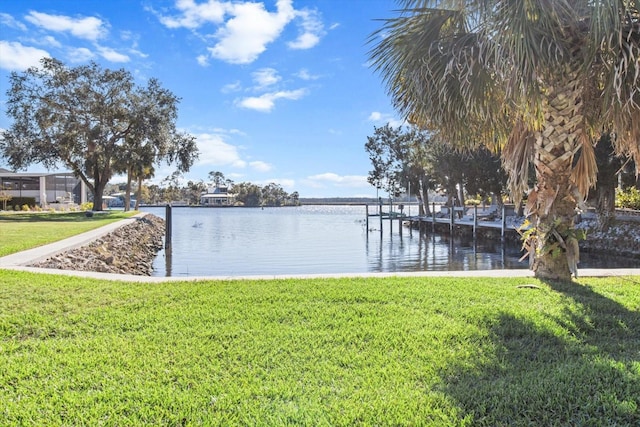 view of dock featuring a lawn and a water view