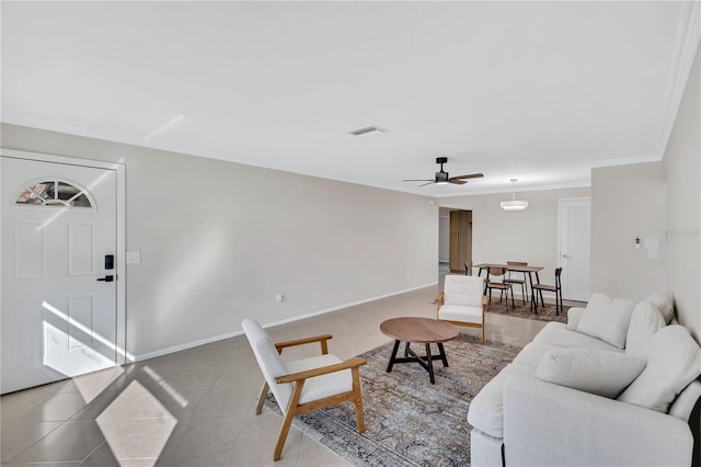 living room featuring tile patterned flooring, ceiling fan, and ornamental molding