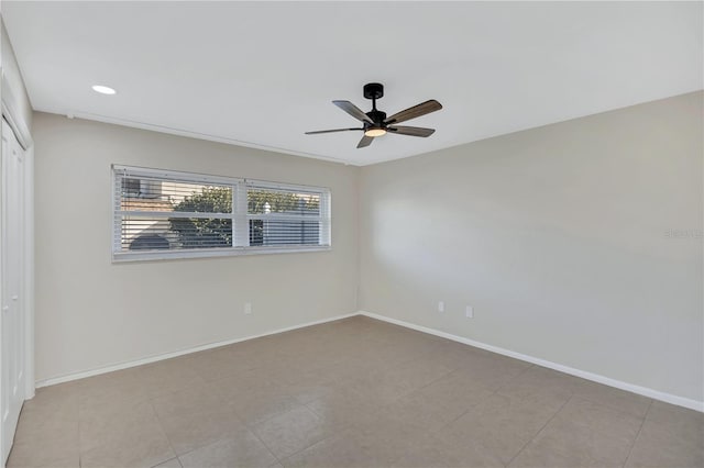 tiled empty room featuring ceiling fan