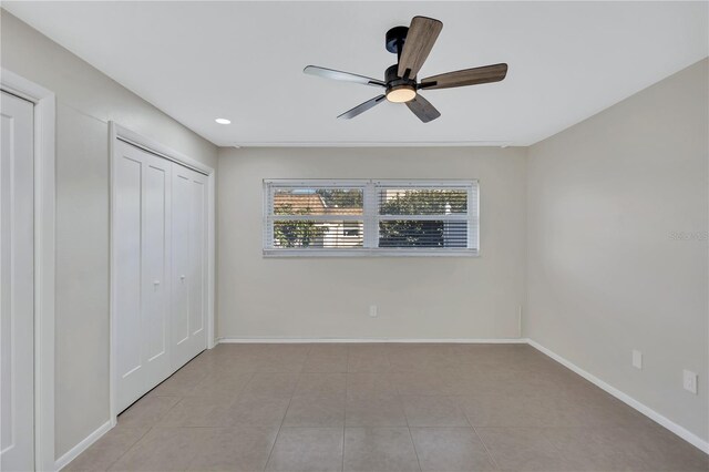 unfurnished bedroom featuring light tile patterned floors, a closet, and ceiling fan