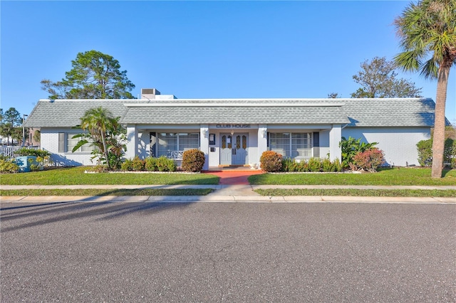 ranch-style home with a front lawn and covered porch