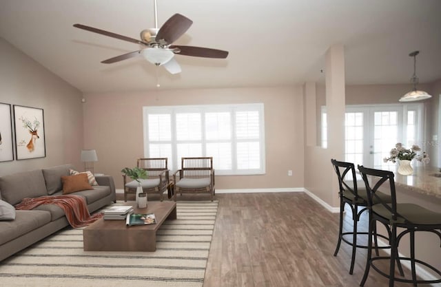 living room featuring french doors, ceiling fan, a wealth of natural light, and wood-type flooring