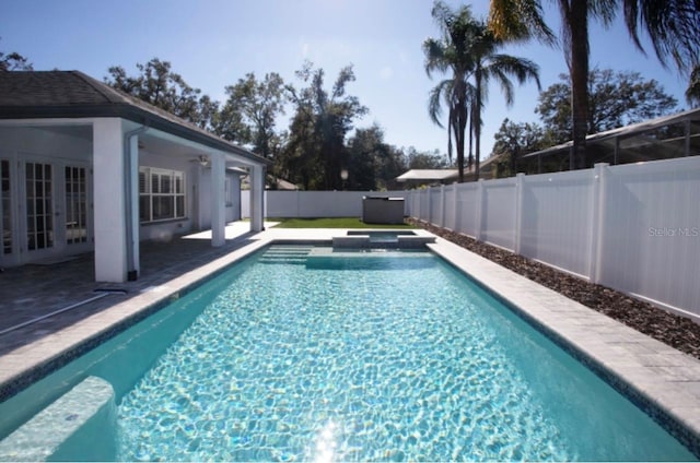 view of pool with a patio area, an in ground hot tub, and french doors