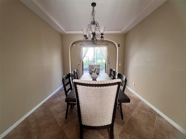 dining room with a textured ceiling, an inviting chandelier, and dark tile patterned floors