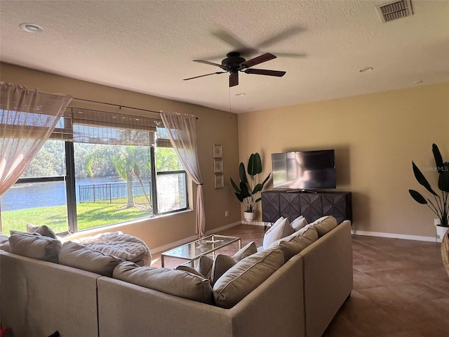 tiled living room with a textured ceiling and ceiling fan