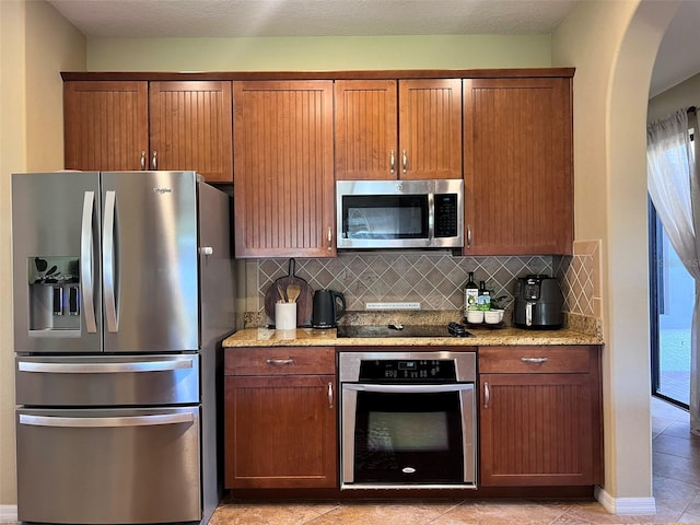 kitchen with tasteful backsplash, a wealth of natural light, and appliances with stainless steel finishes