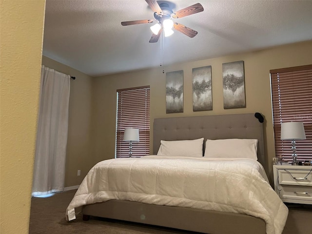 bedroom featuring dark colored carpet, ceiling fan, and a textured ceiling