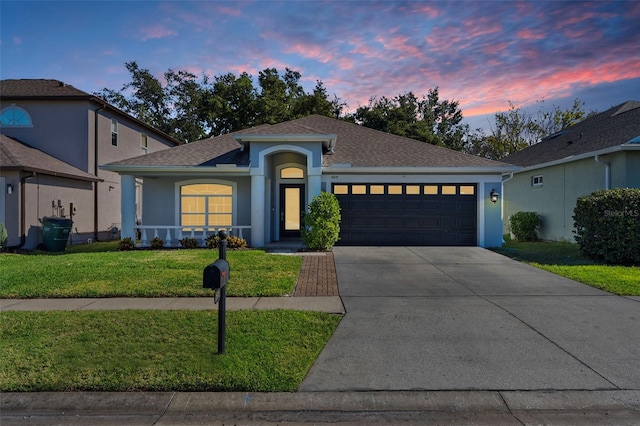 view of front of property featuring a lawn and a garage