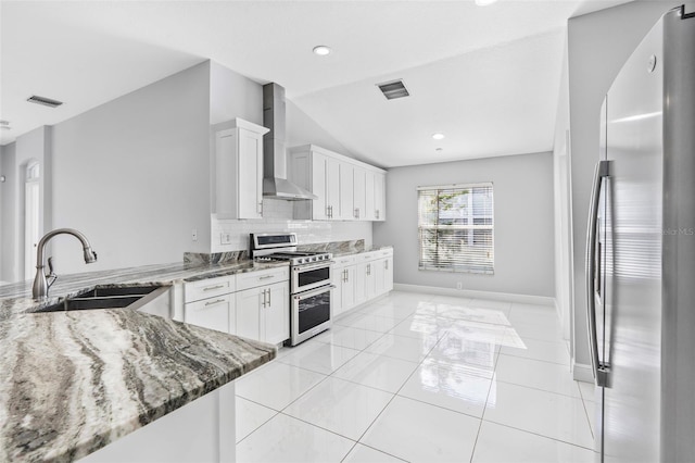 kitchen featuring sink, white cabinets, stainless steel appliances, and wall chimney range hood