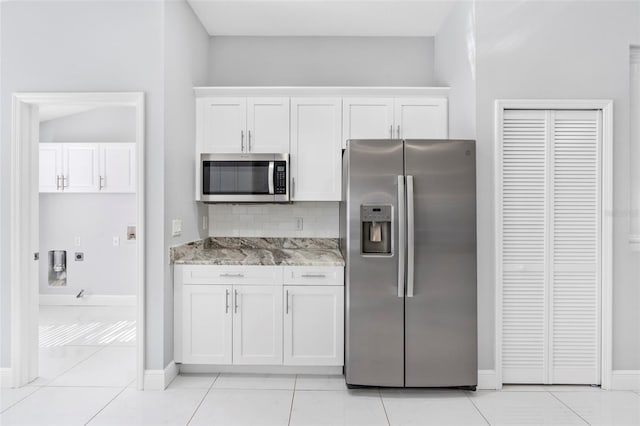 kitchen featuring backsplash, white cabinetry, stainless steel appliances, and light stone counters