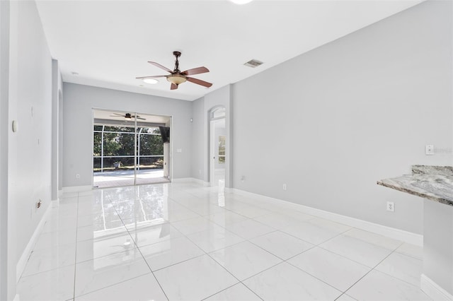 tiled spare room with ceiling fan