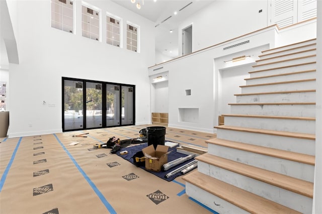 living room with french doors and a high ceiling