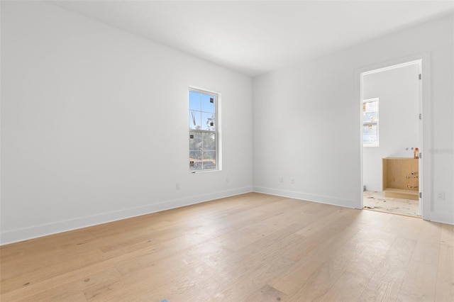 empty room with a wealth of natural light and light wood-type flooring