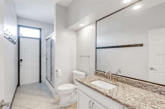 bathroom with tile patterned flooring, vanity, toilet, and a shower with shower door