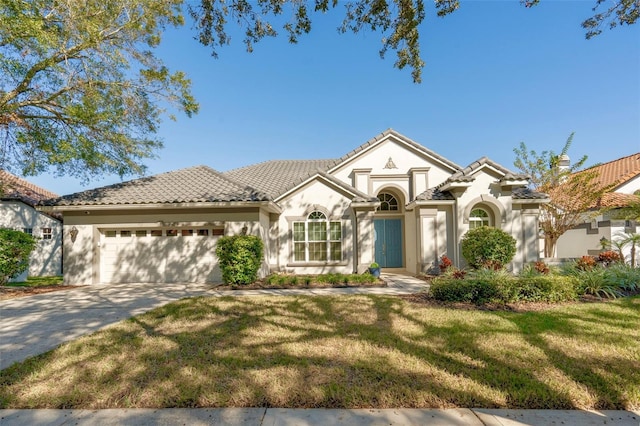 mediterranean / spanish house with a front lawn and a garage