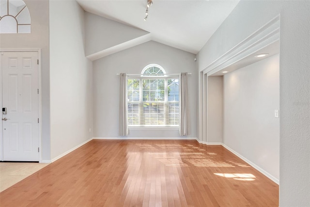 foyer featuring wood-type flooring and lofted ceiling