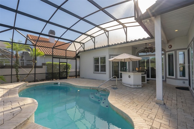 view of pool featuring glass enclosure, ceiling fan, and a patio