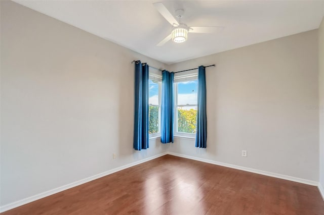 unfurnished room with ceiling fan and dark wood-type flooring