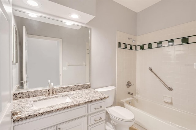 full bathroom featuring vanity, tiled shower / bath combo, and toilet