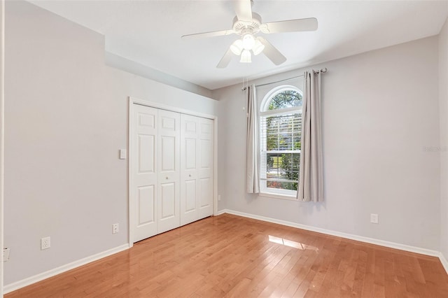 unfurnished bedroom featuring a closet, light hardwood / wood-style flooring, and ceiling fan