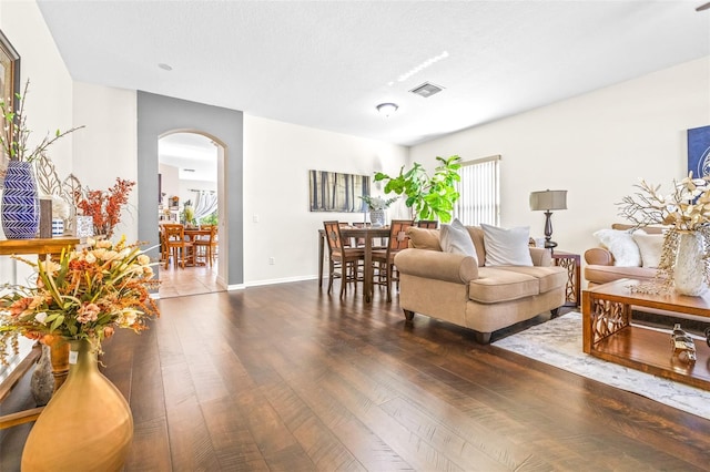 living room with dark hardwood / wood-style floors and a textured ceiling