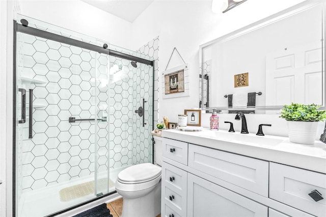 bathroom with walk in shower, tile patterned floors, vanity, and toilet