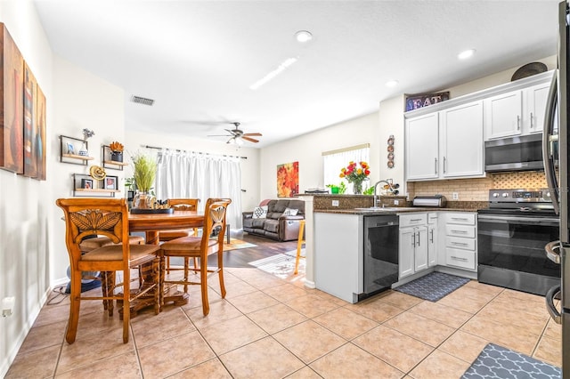 kitchen with white cabinetry, appliances with stainless steel finishes, kitchen peninsula, and decorative backsplash