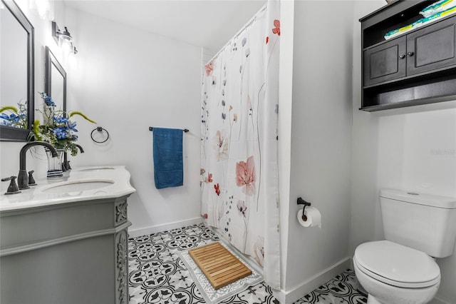 bathroom featuring a shower with curtain, vanity, toilet, baseboards, and tile patterned flooring