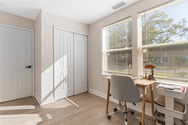 office space featuring baseboards, visible vents, and light wood-style flooring