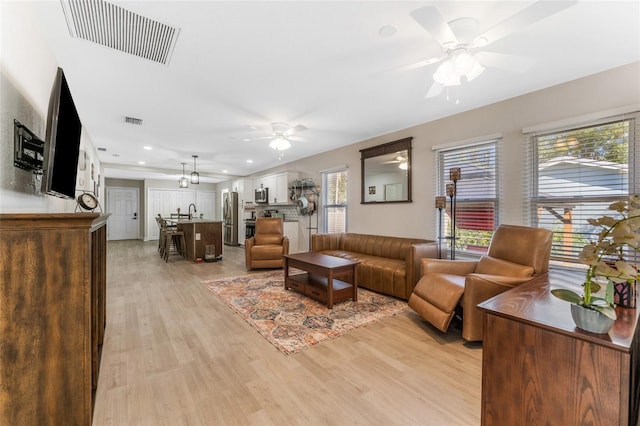 living area with recessed lighting, a ceiling fan, visible vents, and light wood-type flooring