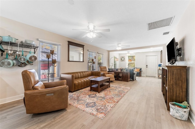 living room featuring visible vents, a ceiling fan, and light wood-style flooring