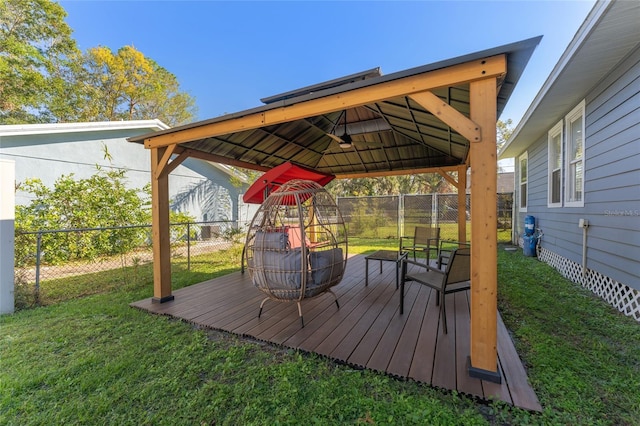 deck featuring a fire pit, a gazebo, a fenced backyard, and a yard