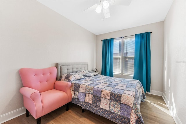 bedroom featuring wood finished floors, ceiling fan, vaulted ceiling, and baseboards