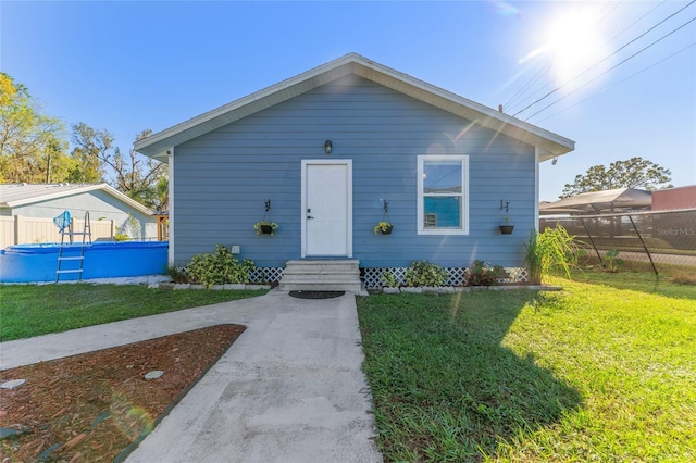 bungalow featuring fence, entry steps, a front yard, and a fenced in pool