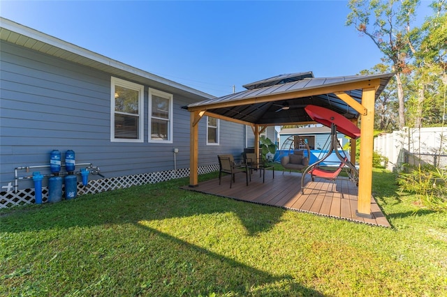 wooden terrace featuring fence, a gazebo, and a yard