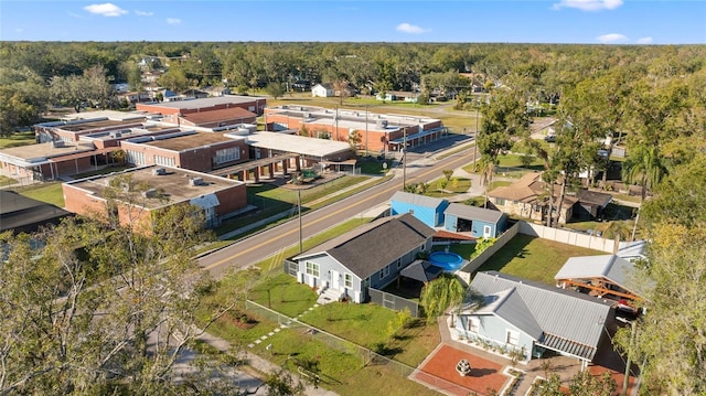 drone / aerial view featuring a wooded view and a residential view
