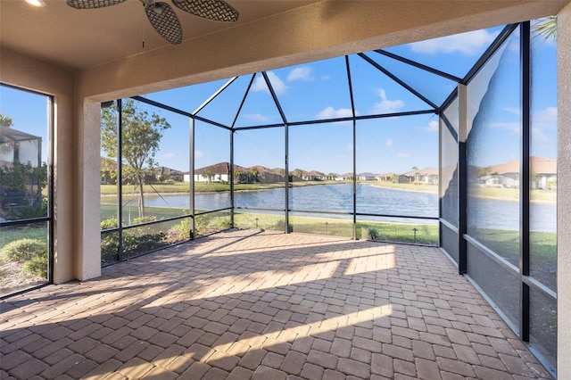 unfurnished sunroom with a water view and ceiling fan