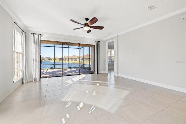 tiled spare room with a wealth of natural light, ceiling fan, a water view, and ornamental molding