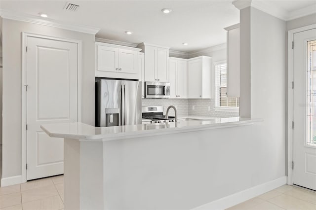 kitchen with kitchen peninsula, light tile patterned flooring, white cabinets, and stainless steel appliances