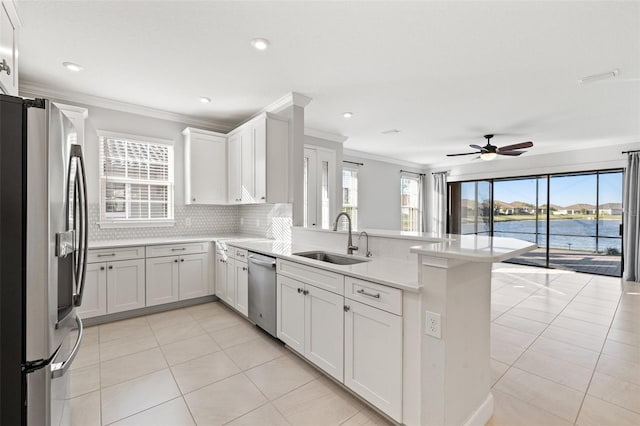 kitchen with white cabinets, a water view, sink, kitchen peninsula, and stainless steel appliances