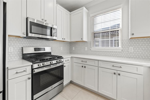 kitchen featuring white cabinets, appliances with stainless steel finishes, backsplash, and light tile patterned floors