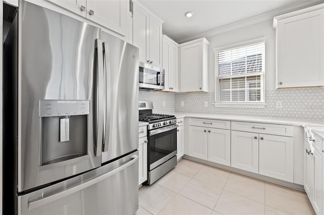 kitchen featuring decorative backsplash, stainless steel appliances, crown molding, white cabinetry, and light tile patterned flooring