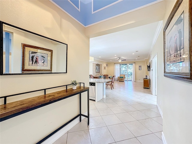 hall featuring crown molding and light tile patterned floors