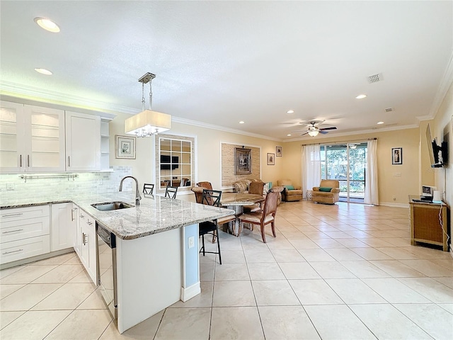 kitchen featuring kitchen peninsula, a kitchen breakfast bar, sink, decorative light fixtures, and white cabinets