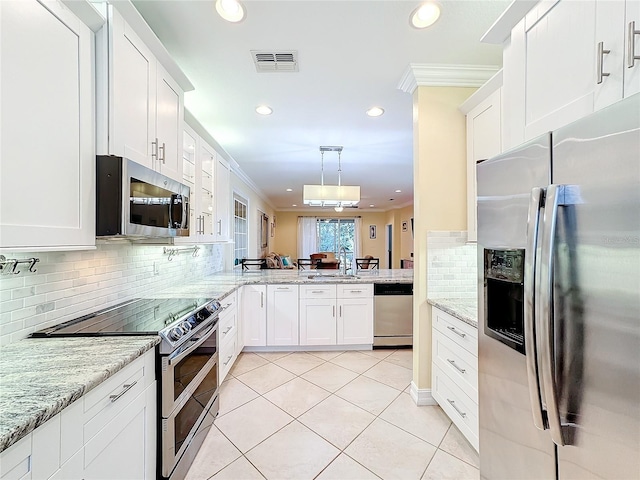 kitchen with white cabinetry, appliances with stainless steel finishes, pendant lighting, light tile patterned floors, and ornamental molding